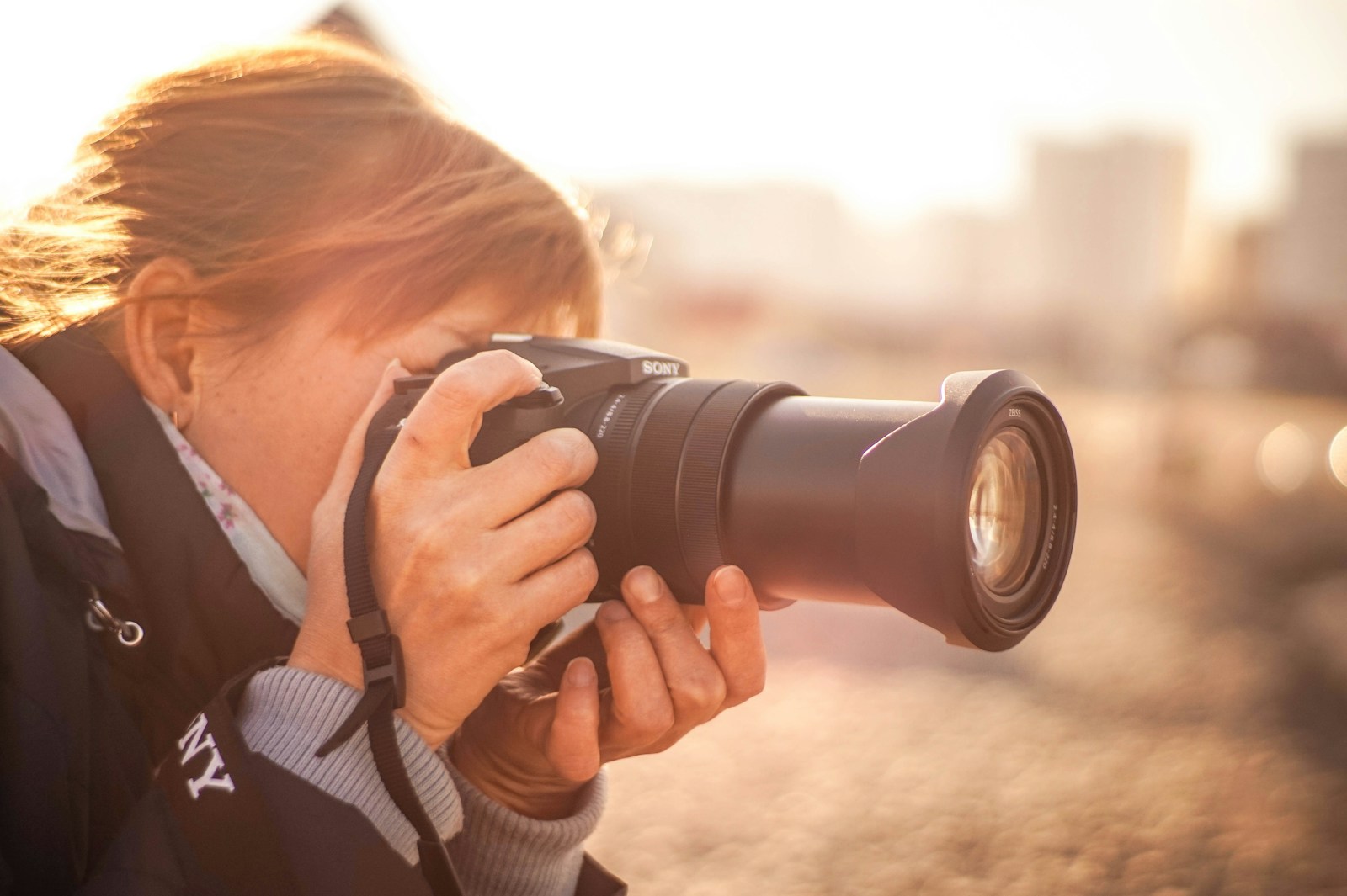 woman using black Sony DSLR camera